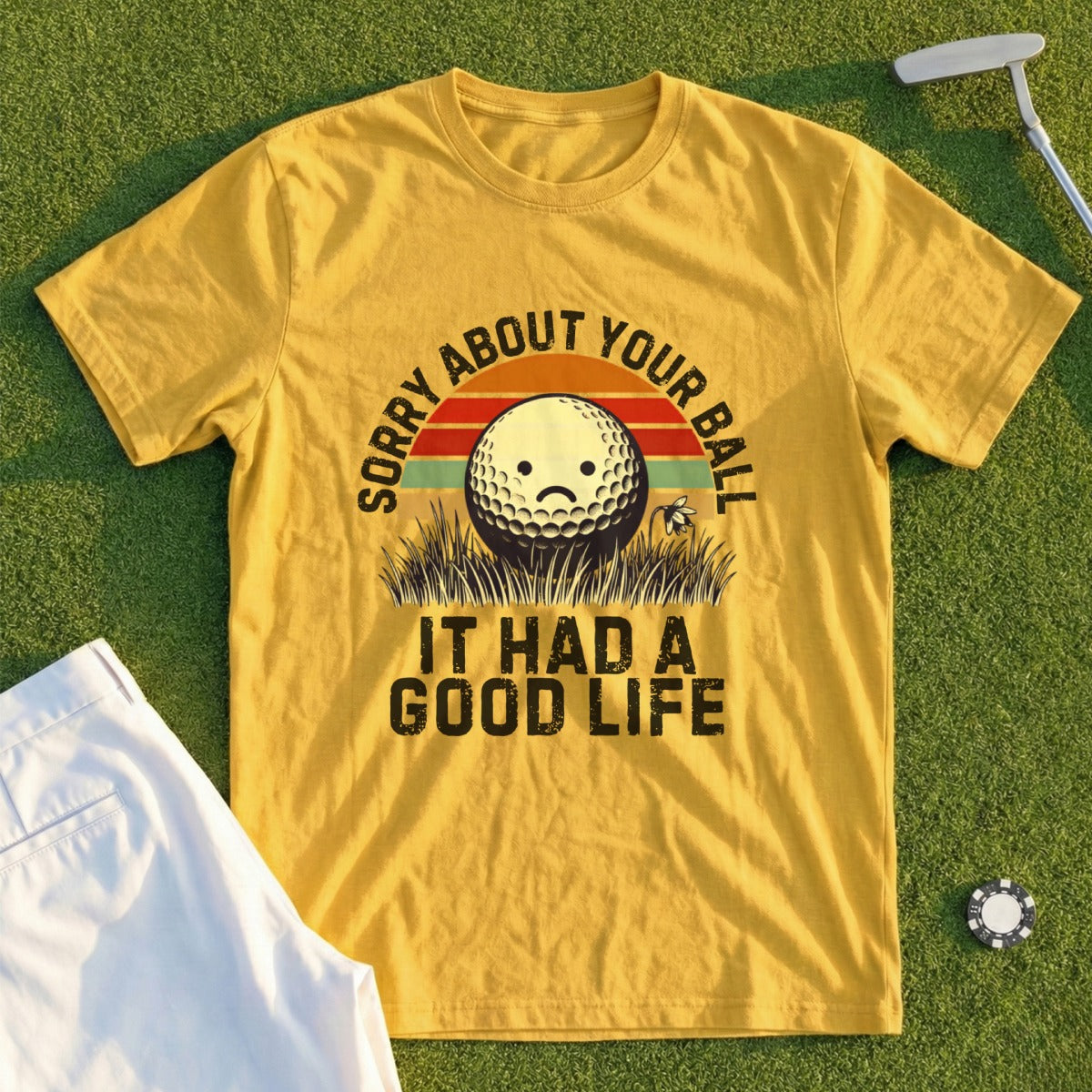 Yellow t-shirt with graphic of sad golf ball and text: SORRY ABOUT YOUR BALL IT HAD A GOOD LIFE.