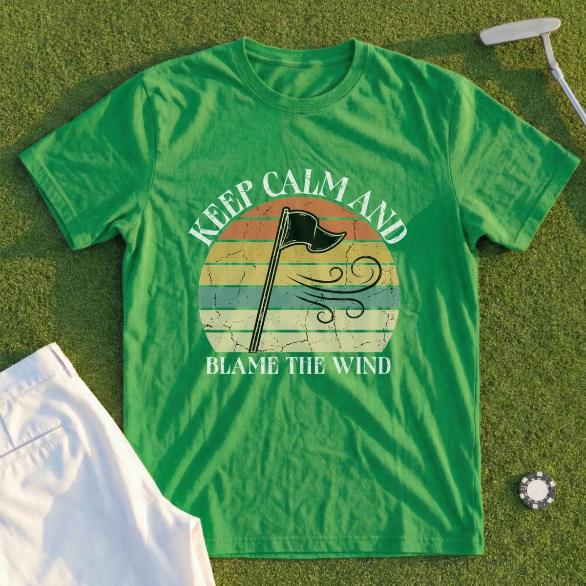 Green t-shirt with "Keep Calm and Blame the Wind" text and a vintage sunset graphic.