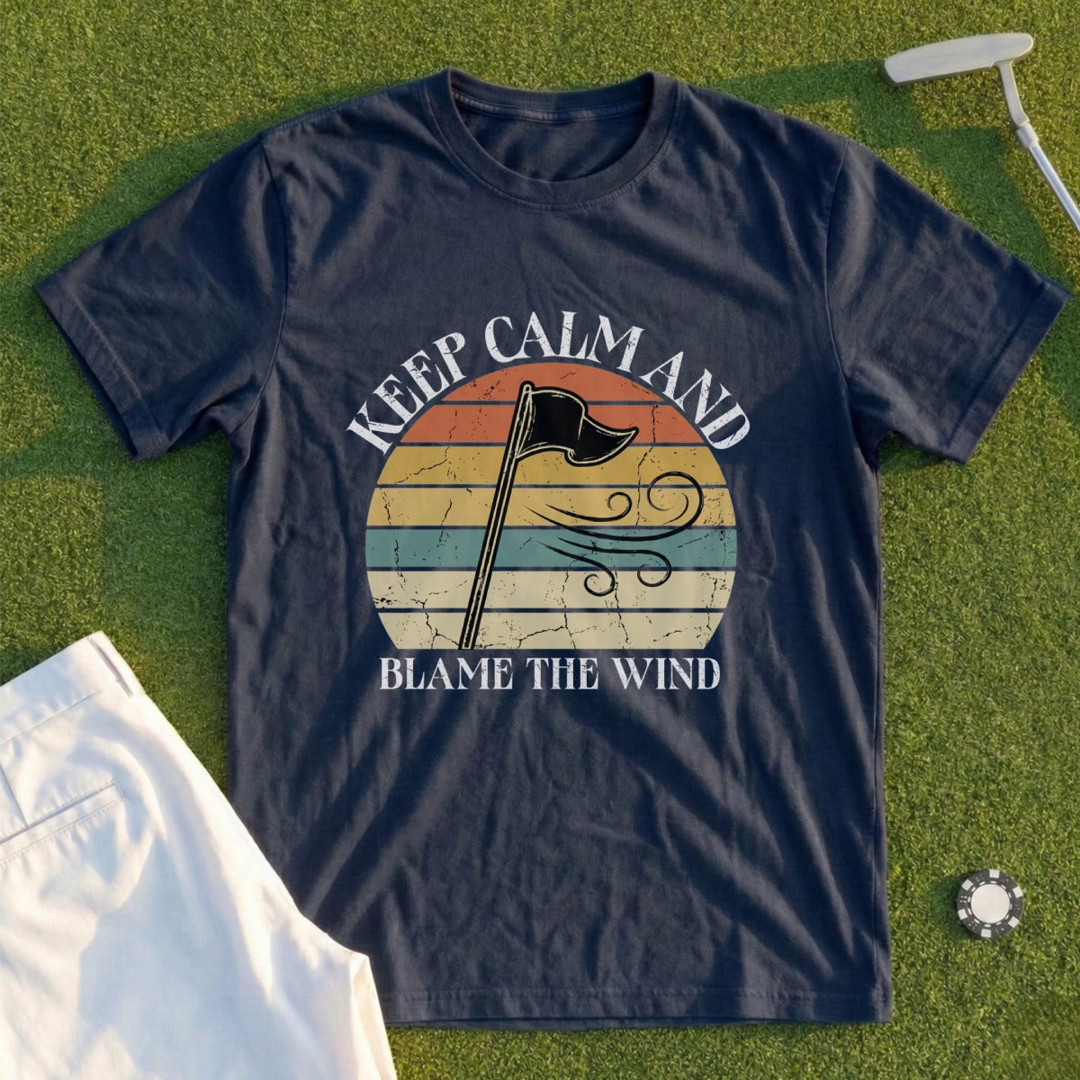 Navy t-shirt with "Keep Calm and Blame the Wind" text and vintage sunset graphic.