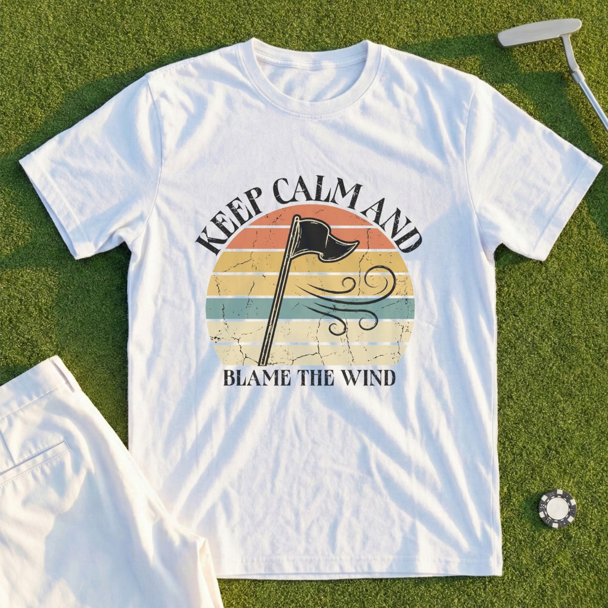 White t-shirt with "Keep Calm and Blame the Wind" text and a vintage distressed flag graphic.