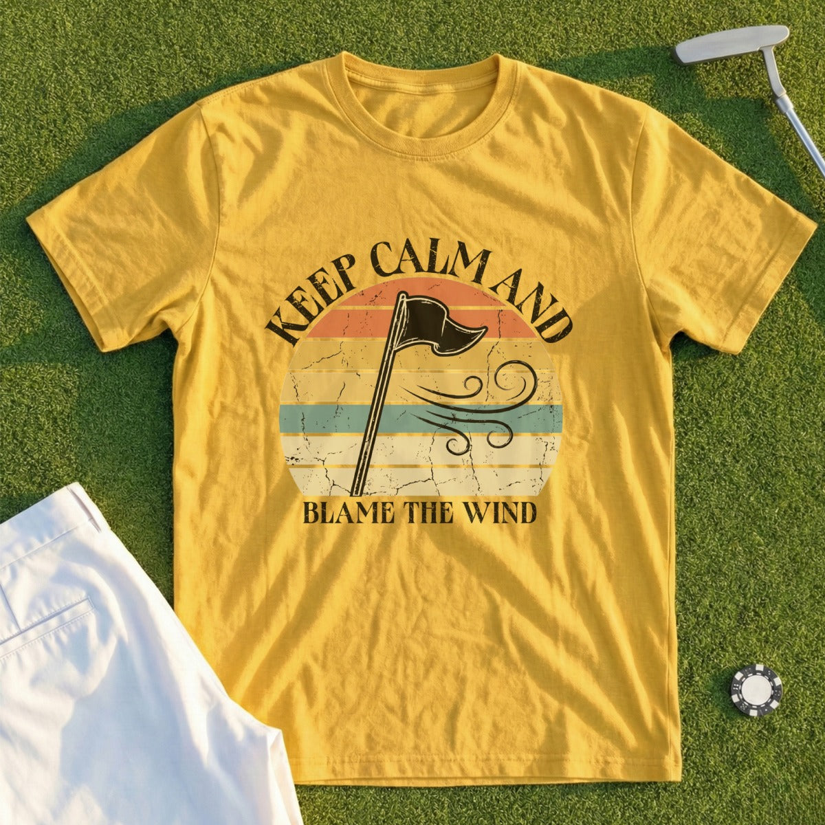 Yellow t-shirt with "Keep Calm and Blame the Wind" graphic and golf accessories.