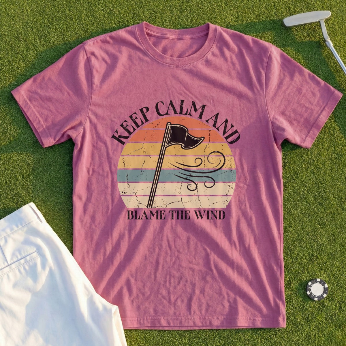 Pink t-shirt with "Keep Calm and Blame the Wind" text and vintage sunset graphic.