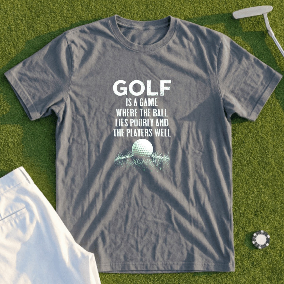 Gray t-shirt with "Golf is a game where the ball lies poorly and the players well" text.