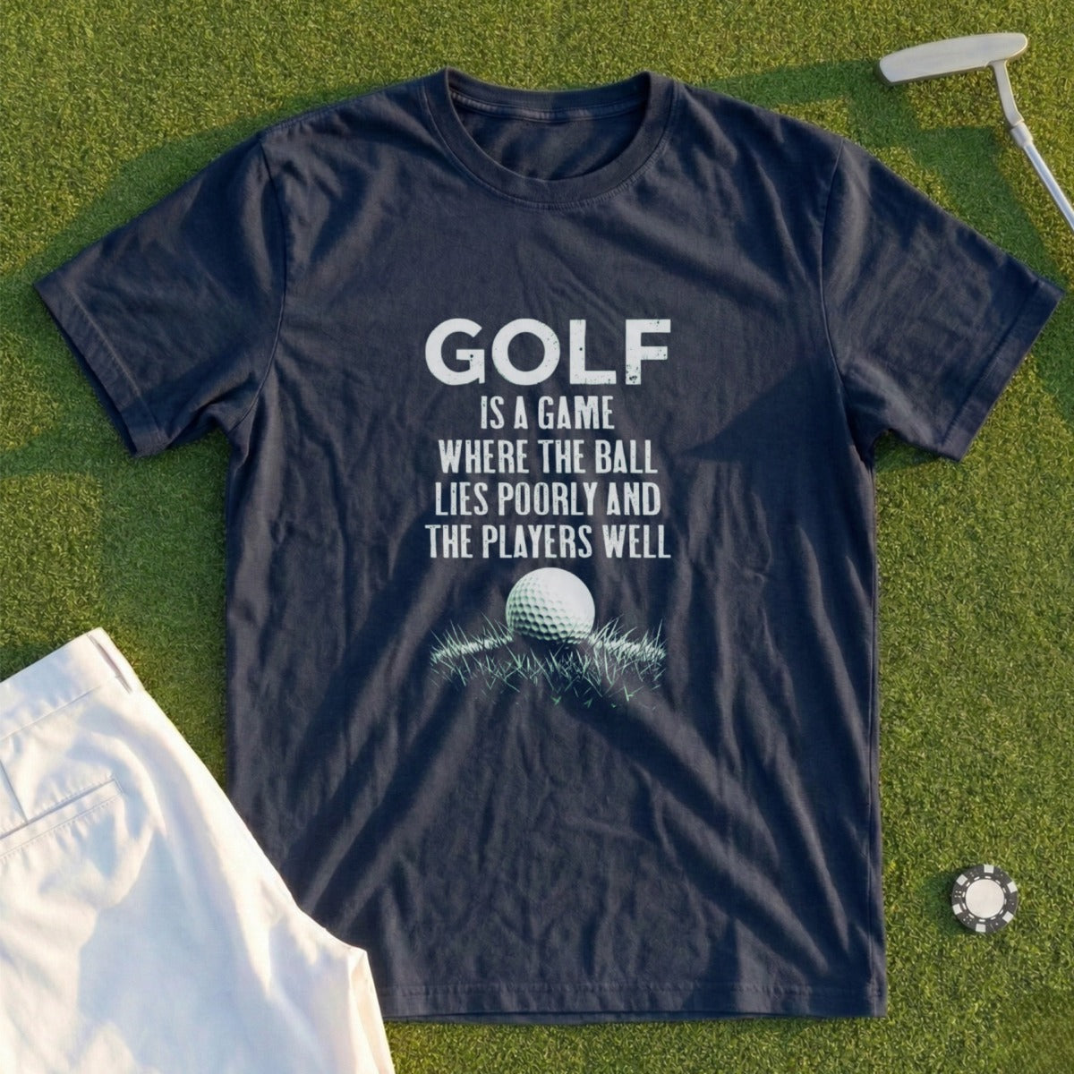 Navy t-shirt with white text about golf and a golf ball on grass.