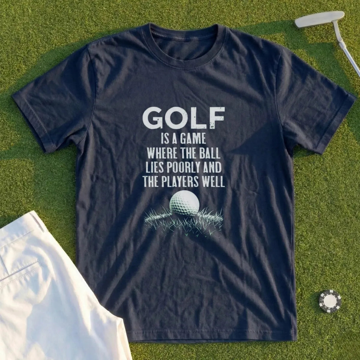 Navy t-shirt with white text about golf and a golf ball on grass.
