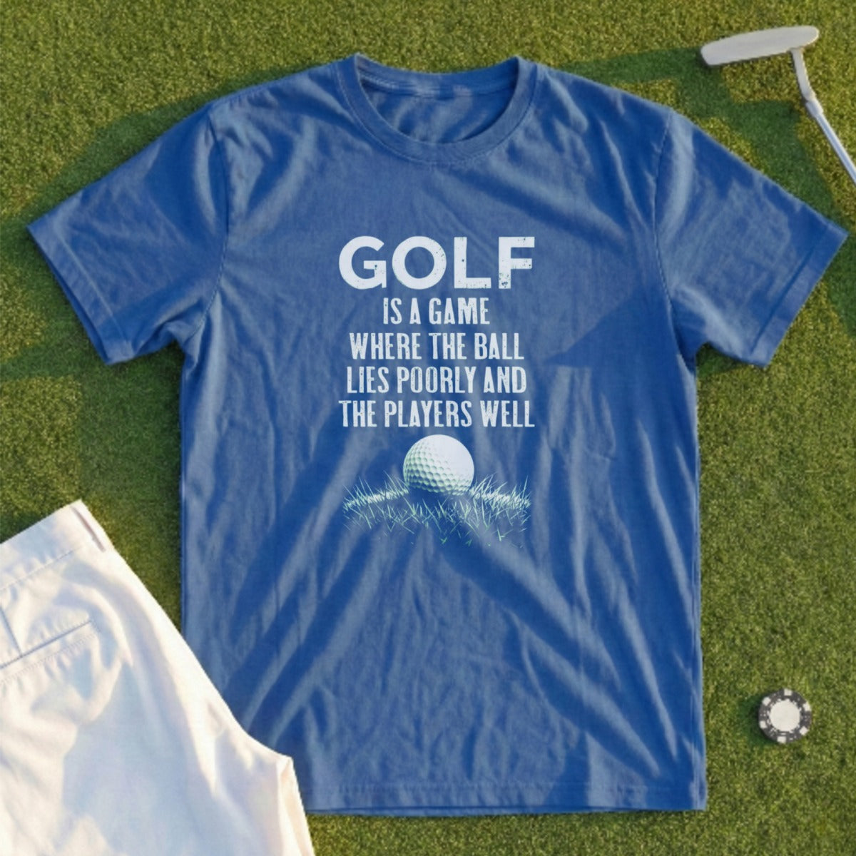 Blue t-shirt with white text and golf ball graphic: "Golf is a game where the ball lies poorly and the players well."