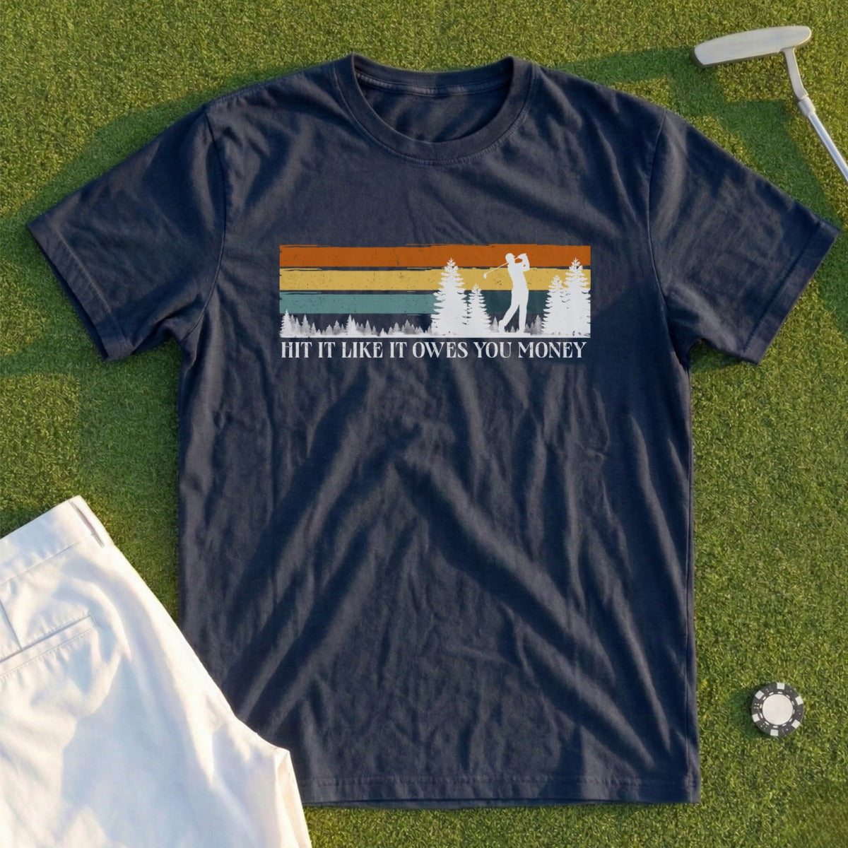 Navy t-shirt with golfer and sunset graphic, text reads "Hit it like you owes money."