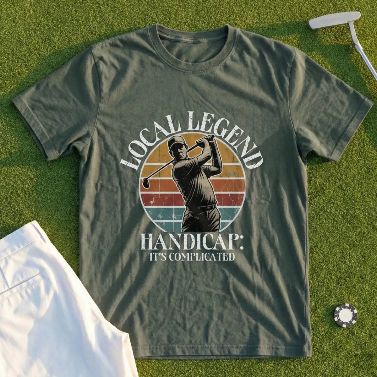 Olive t-shirt with golfer illustration and "Local Legend Handicap: It's Complicated" text.