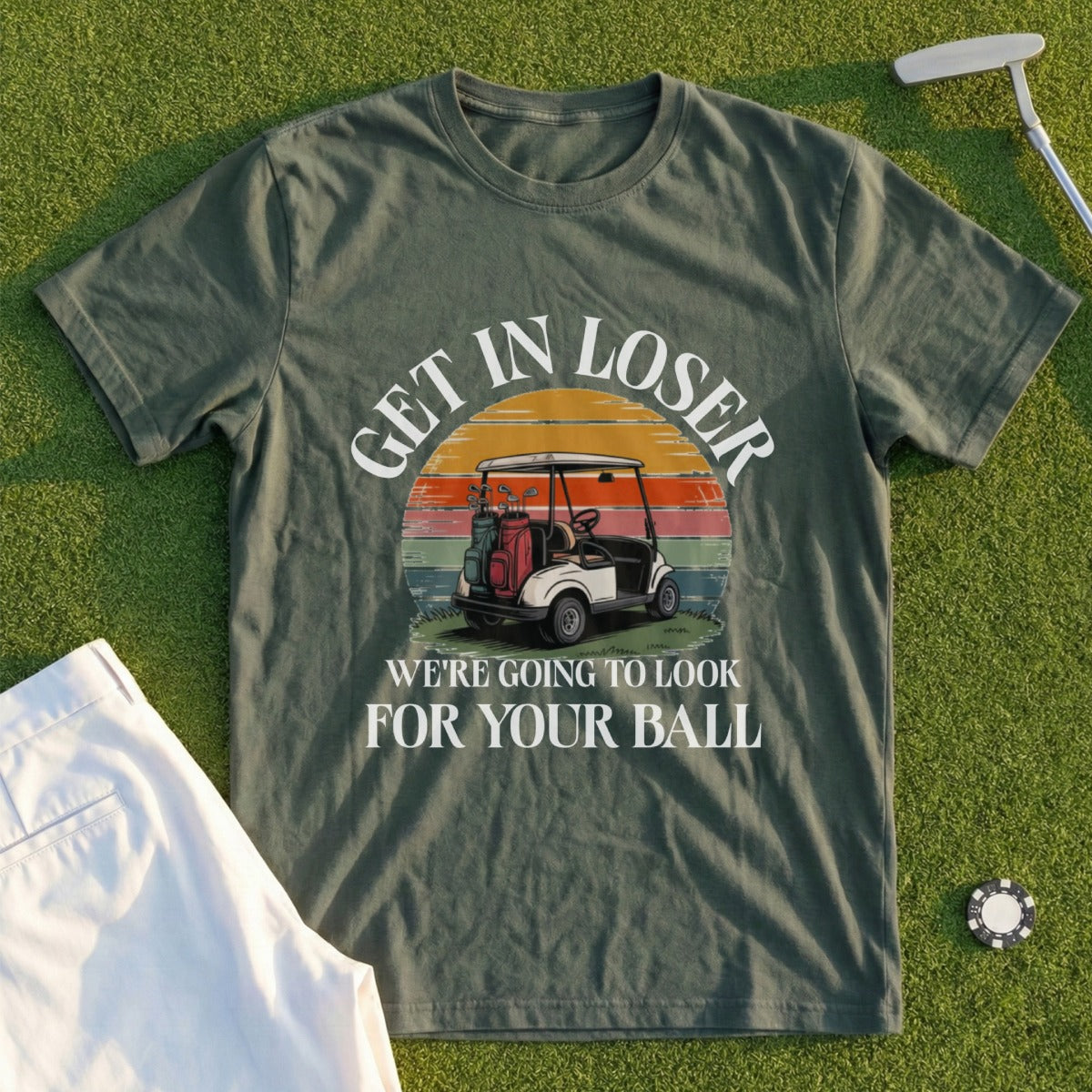 Olive green t-shirt with "GET IN LOSER WE'RE GOING TO LOOK FOR YOUR BALL" text and golf cart graphic.