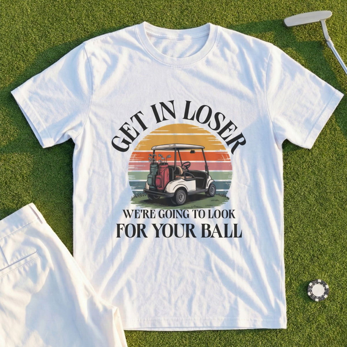White t-shirt with "Get in loser, we're going to look for your ball" and golf cart graphic.