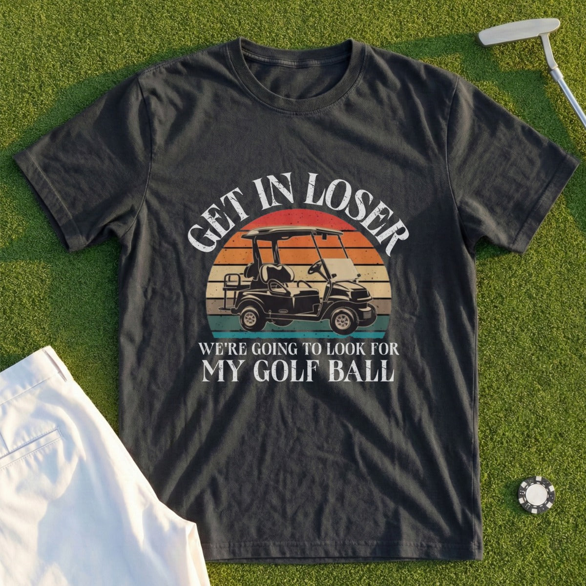 Dark t-shirt with "Get in loser, we're going to look for my golf ball" and golf cart graphic.