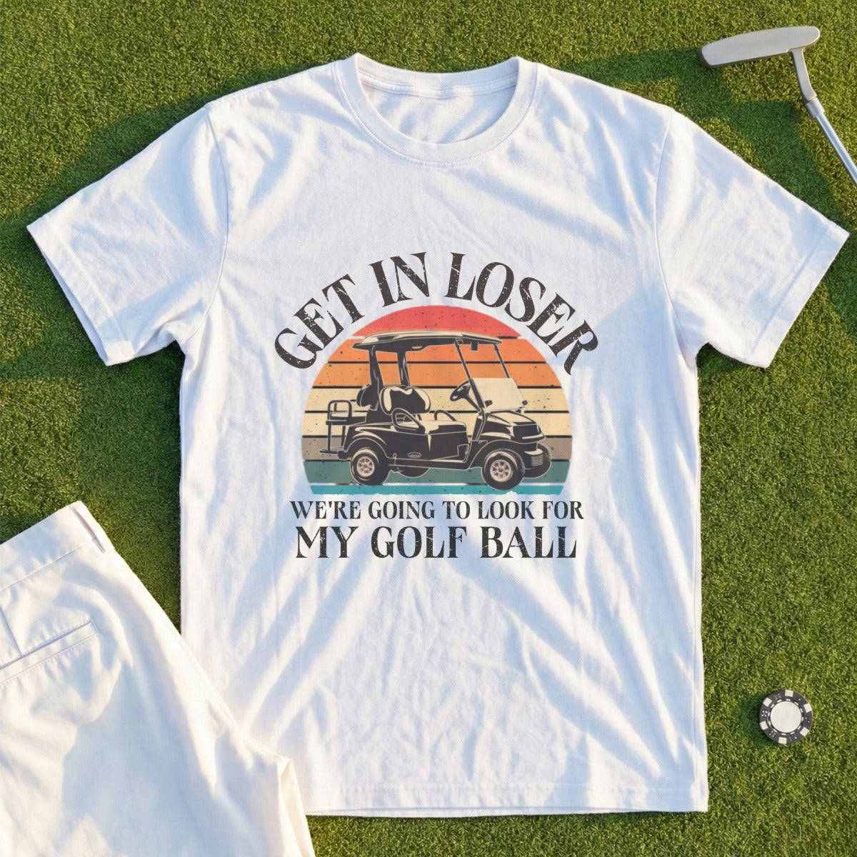 White t-shirt with vintage golf cart graphic and "Get in loser, we're going to look for my golf ball" text.