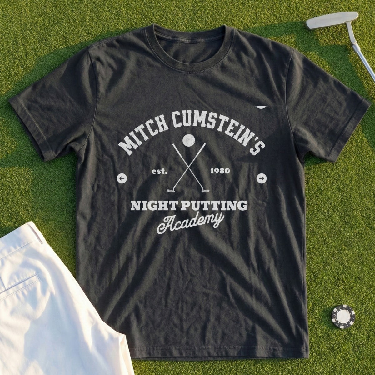 Dark t-shirt with "Mitch Cumstein's Night Putting Academy est. 1980" text.