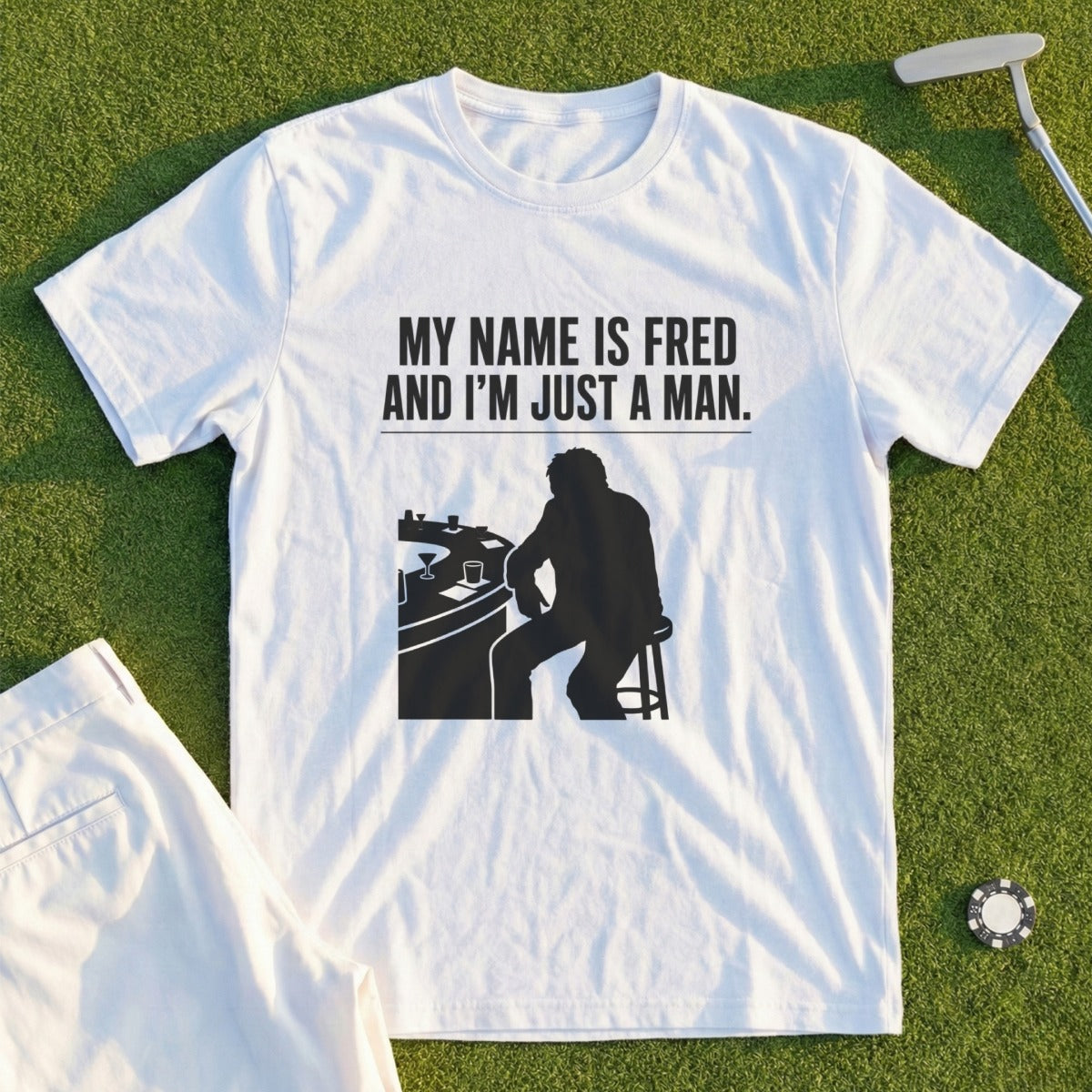 White t-shirt with black graphic: man at bar, text "MY NAME IS FRED AND I'M JUST A MAN."