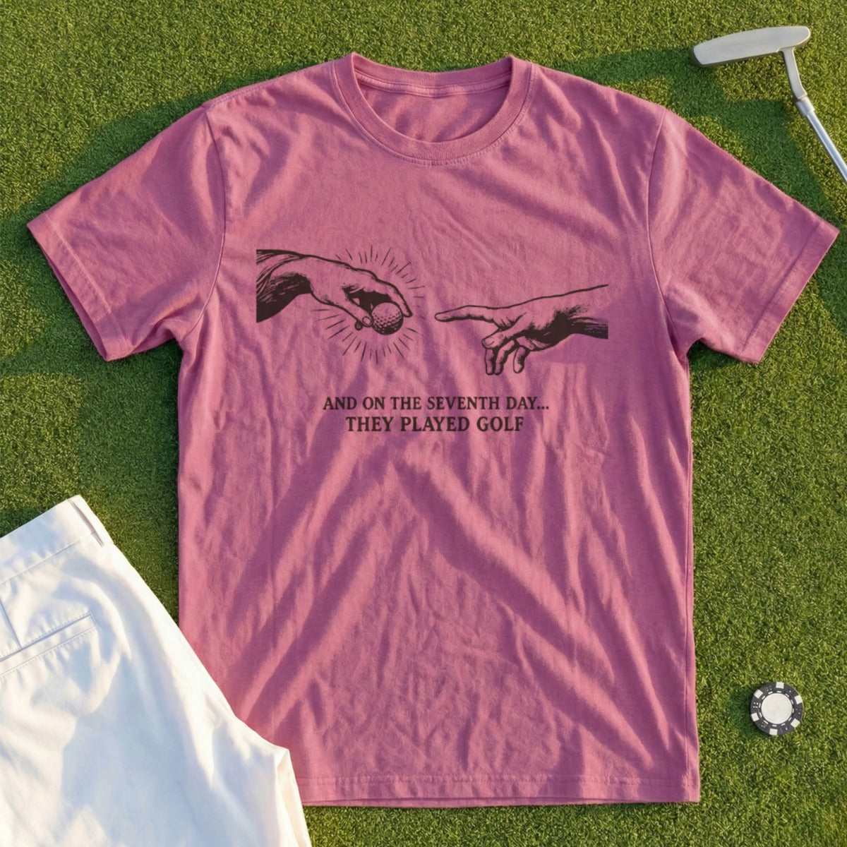 Pink t-shirt with "And on the seventh day... they played golf" text and artwork.