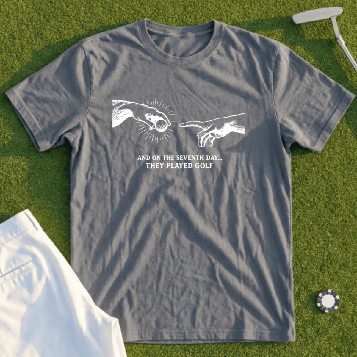 Gray t-shirt with white text "And on the seventh day... they played golf".