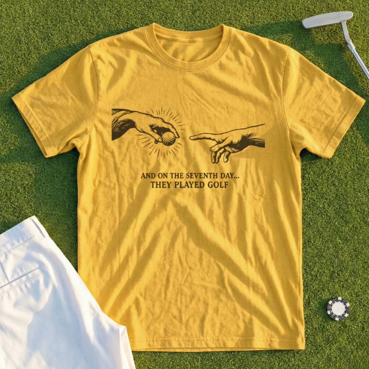 Yellow t-shirt with "And on the seventh day... they played golf" text and The Creation of Adam imagery.