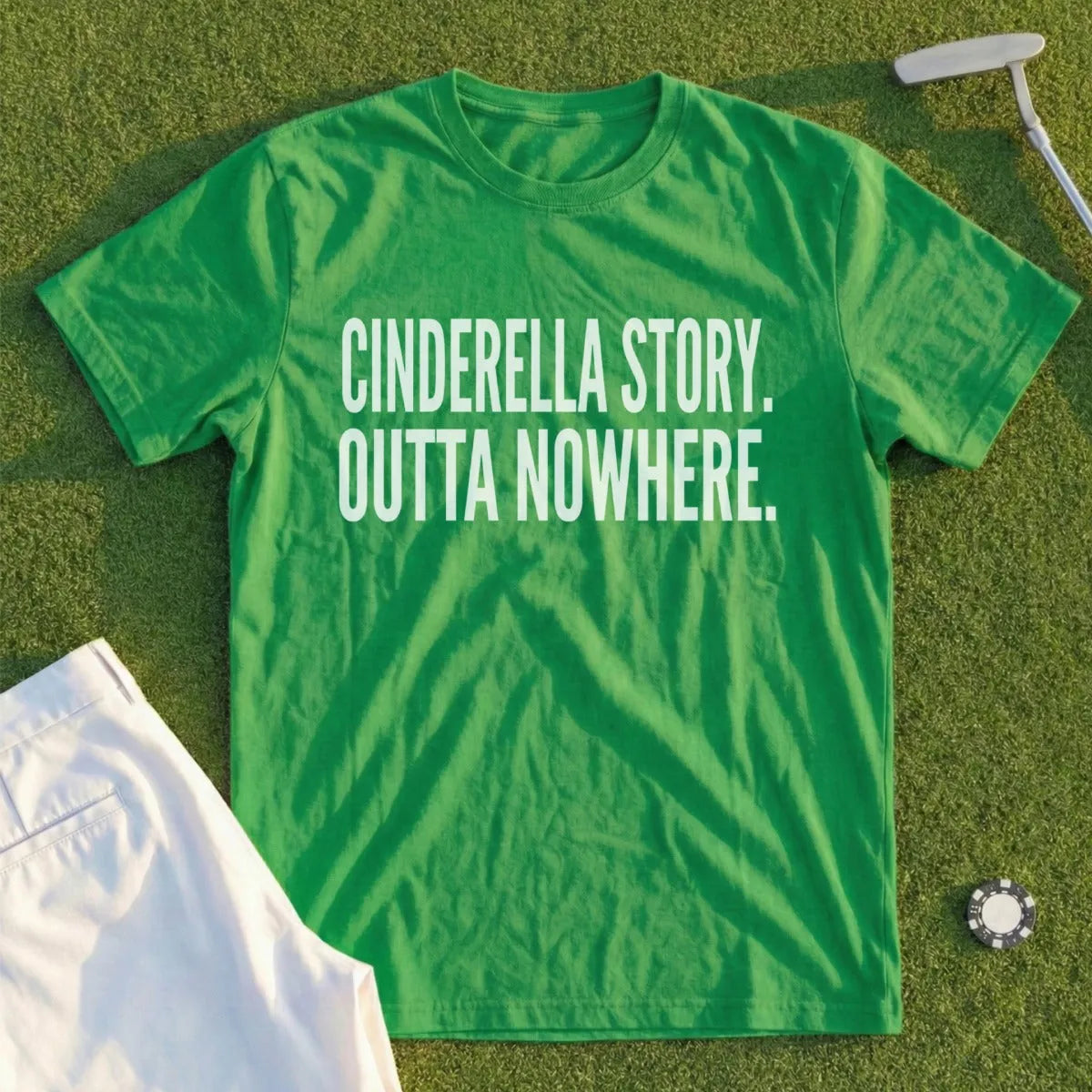 Green t-shirt with white text "CINDERELLA STORY. OUTTA NOWHERE." on a golf course.
