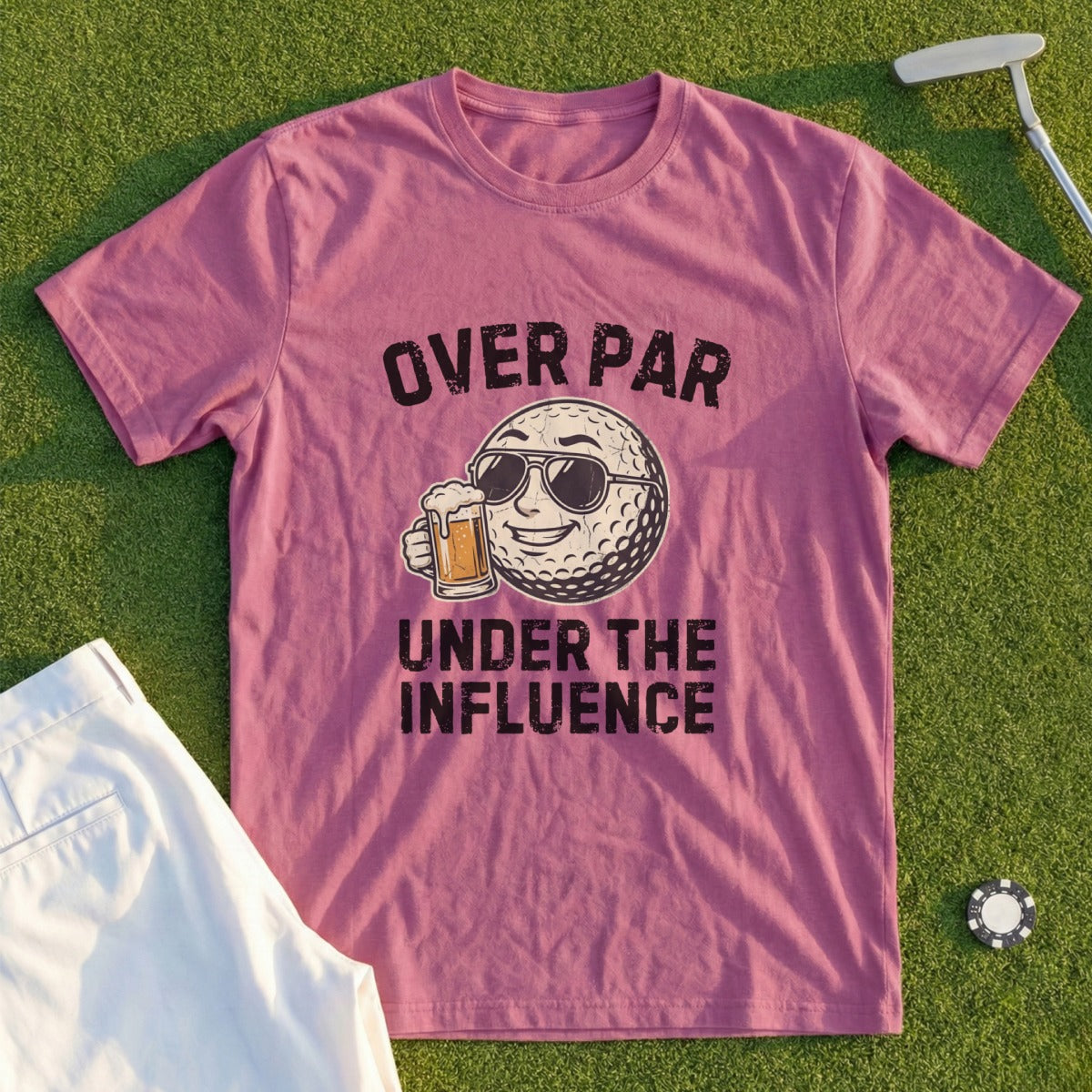 Pink t-shirt with graphic of a golf ball drinking beer, text reads "OVER PAR UNDER THE INFLUENCE".
