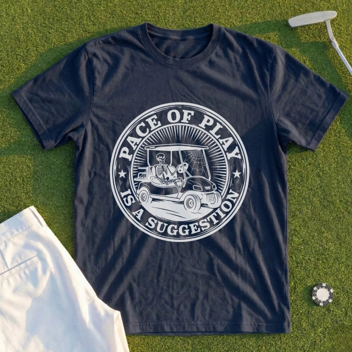Skeleton driving a golf cart on navy t-shirt with "Pace of Play is a Suggestion" text.