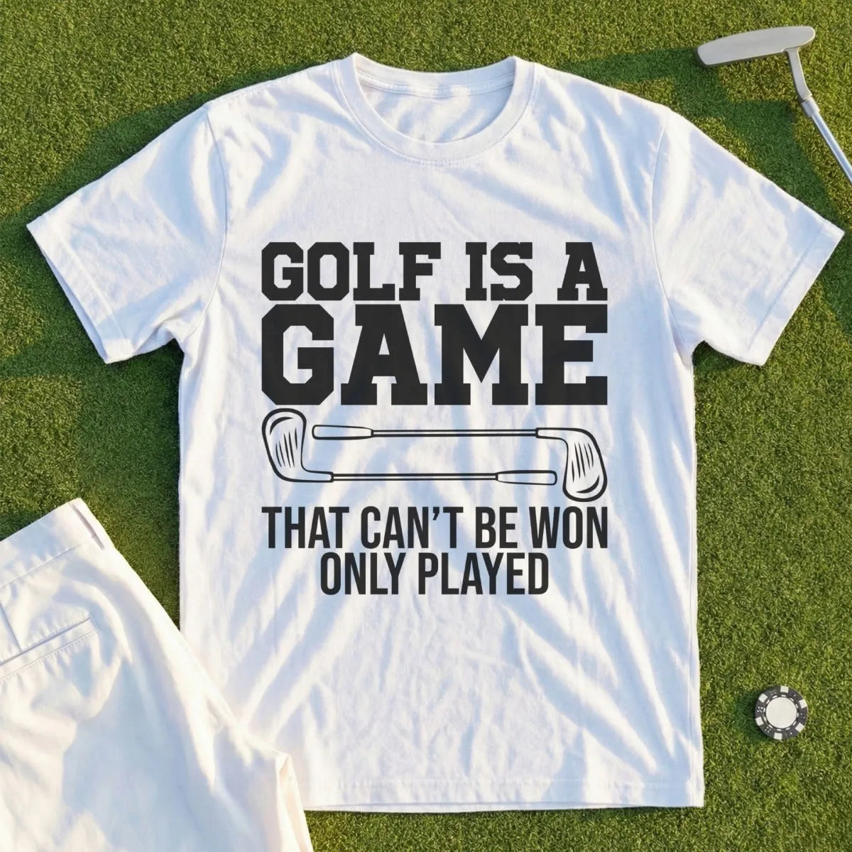 White t-shirt with "GOLF IS A GAME THAT CAN'T BE WON ONLY PLAYED" text and golf clubs.