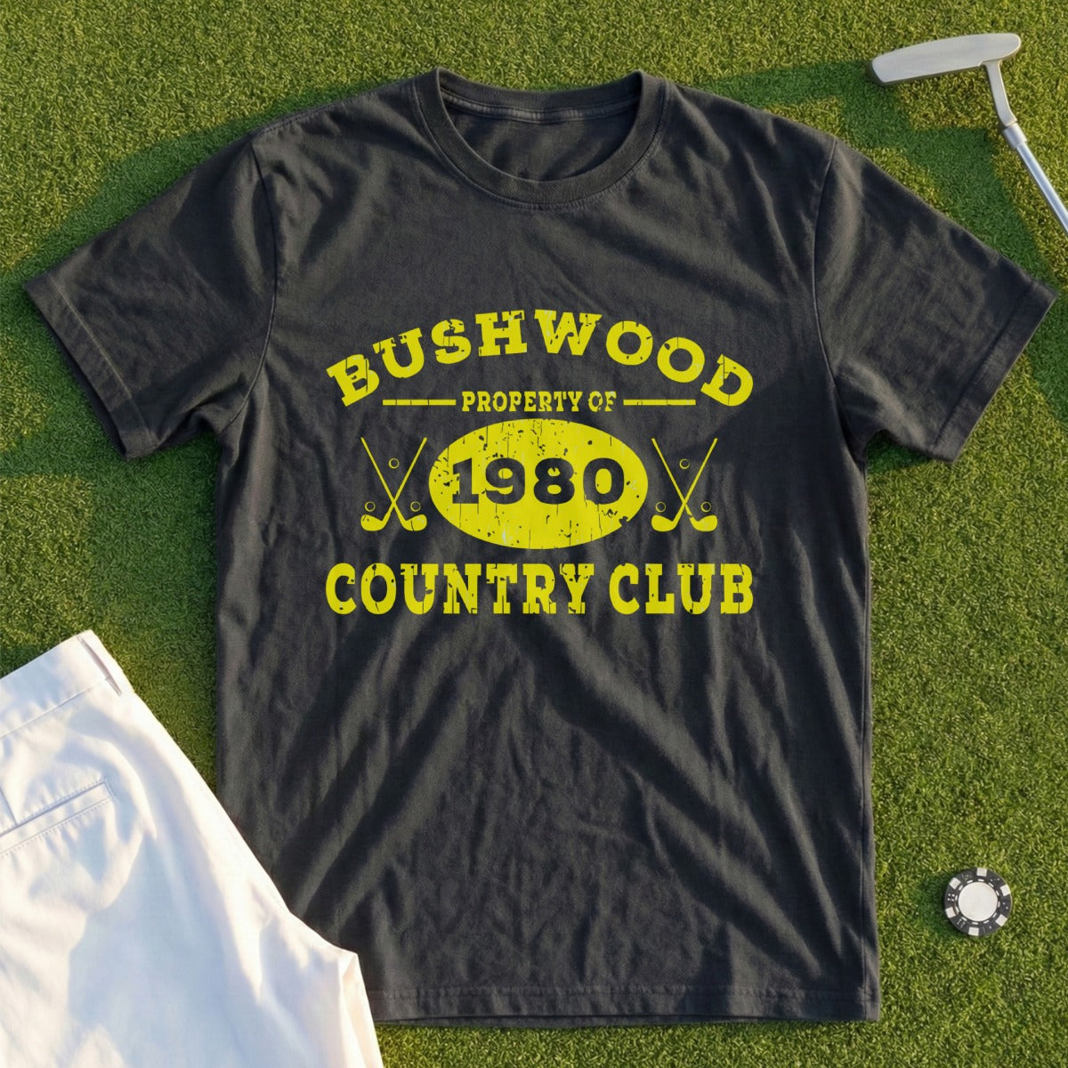 Black t-shirt with yellow "Bushwood Country Club Property of 1980" text and crossed golf clubs.