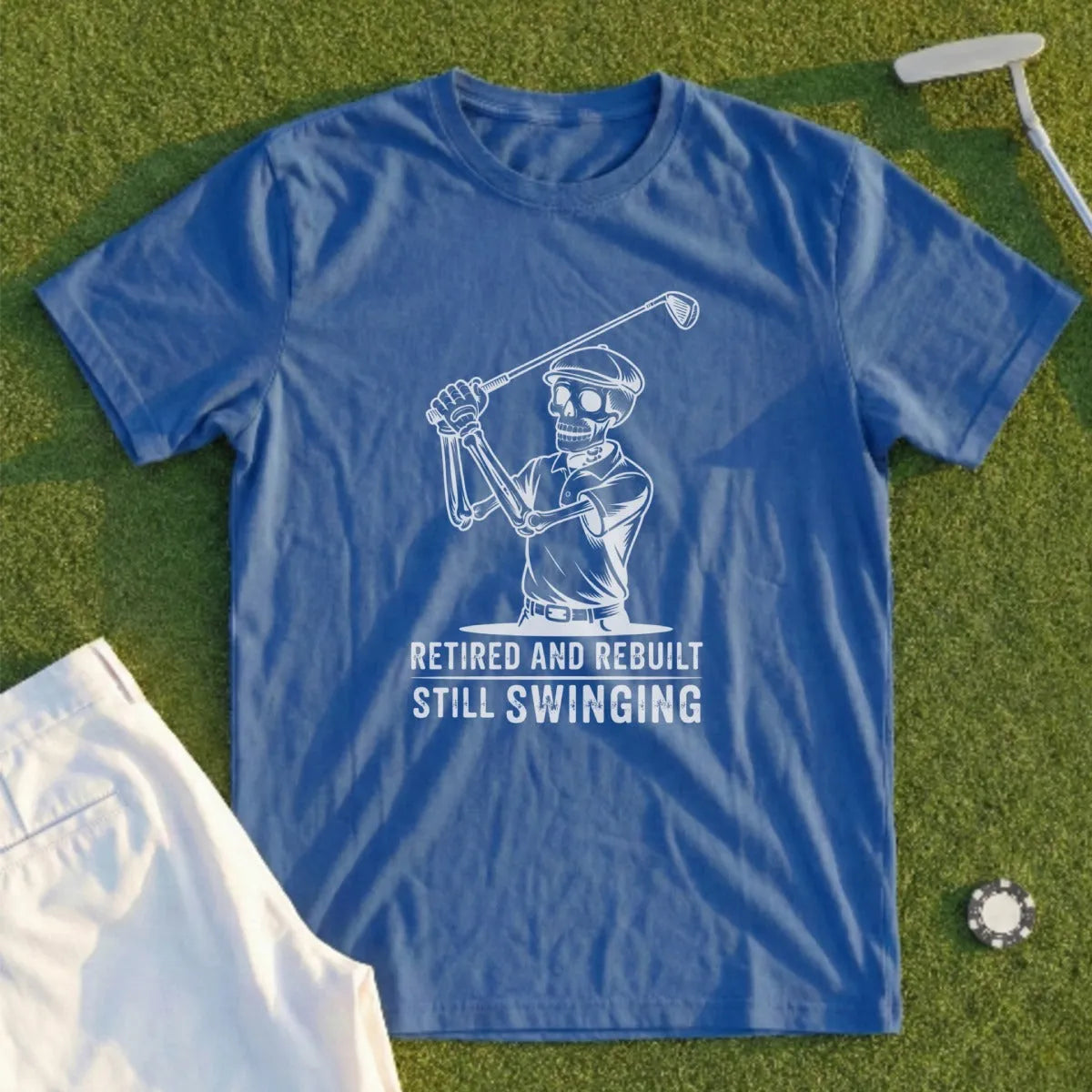 Blue t-shirt with skeleton golfer graphic and text: "Retired and Rebuilt Still Swinging".