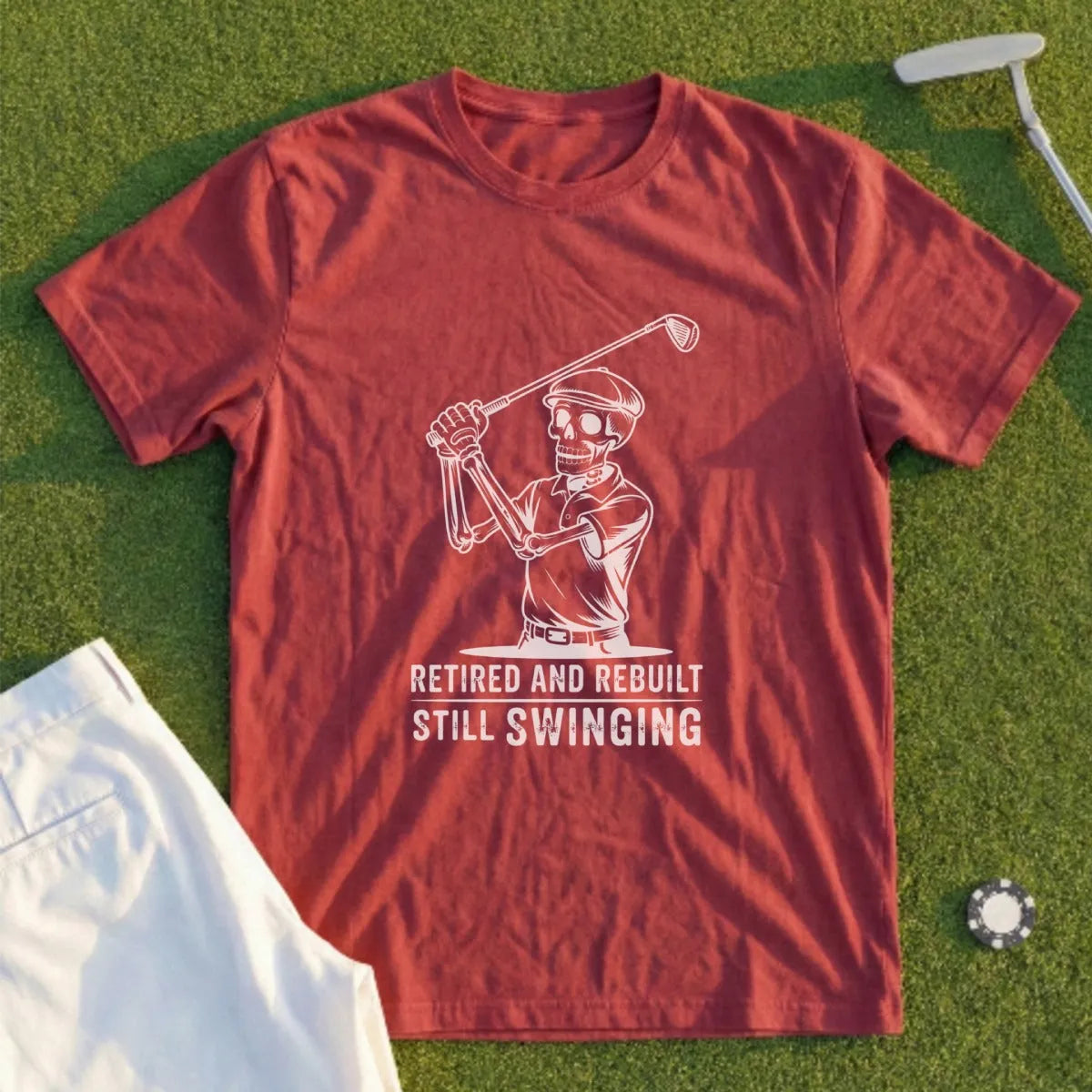 Red t-shirt with skeleton golfer graphic and text "Retired and Rebuilt Still Swinging".