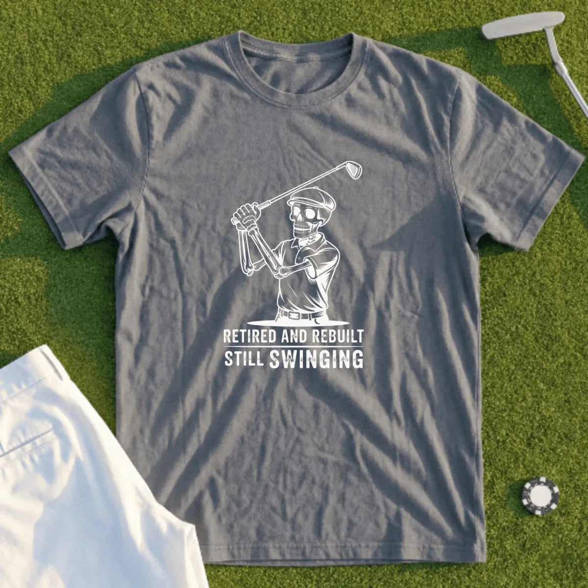 Grey t-shirt with skeleton golfer graphic and text "Retired and Rebuilt Still Swinging".