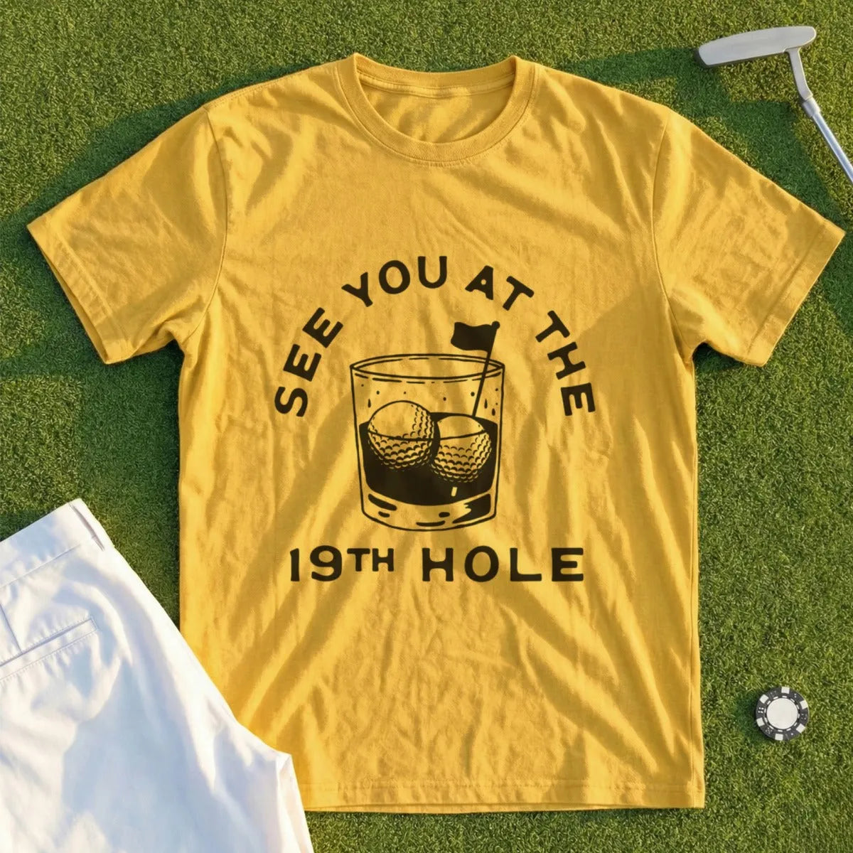 Yellow t-shirt with "SEE YOU AT THE 19TH HOLE" text and golf balls in a glass.