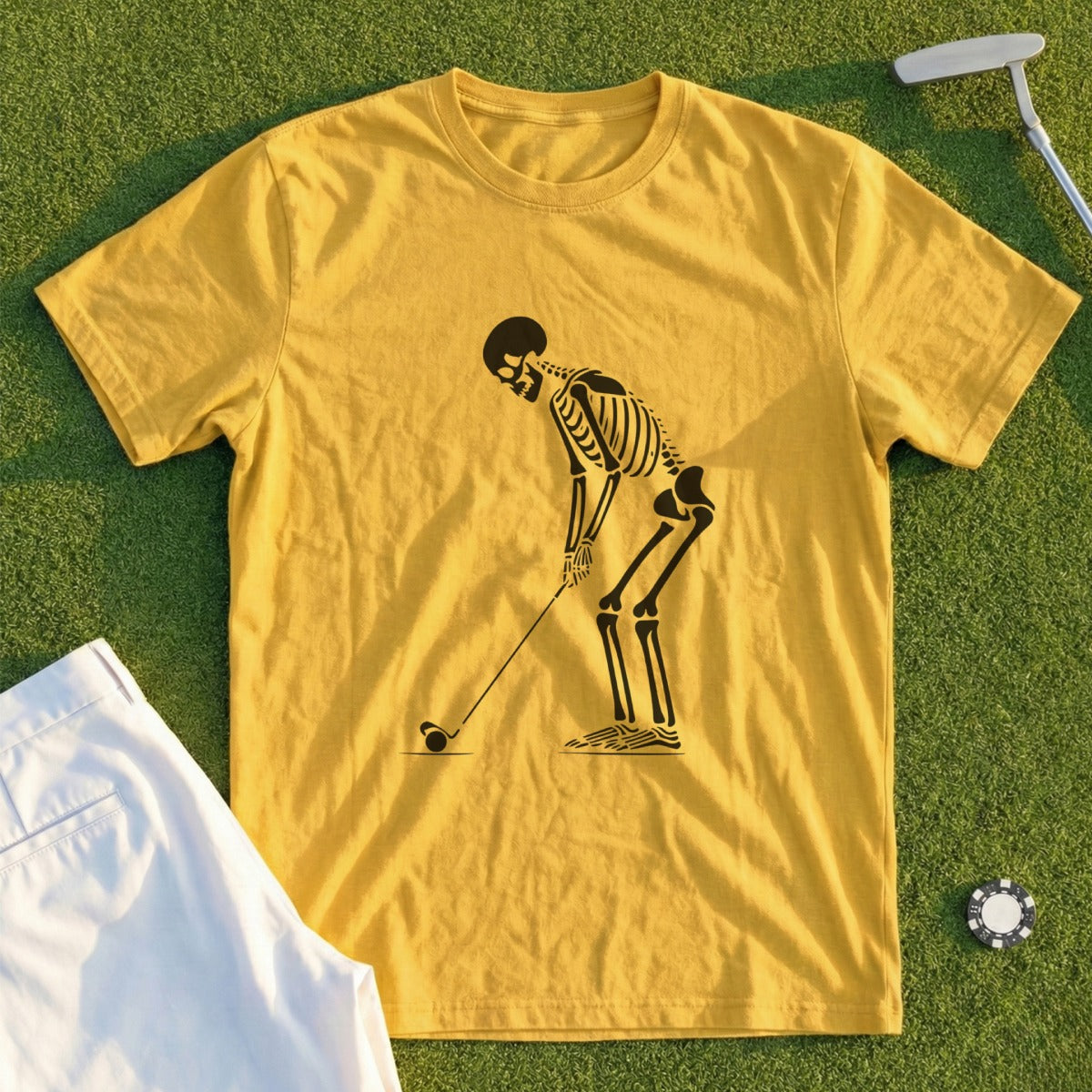 Yellow t-shirt with black skeleton golfing graphic and white pants.