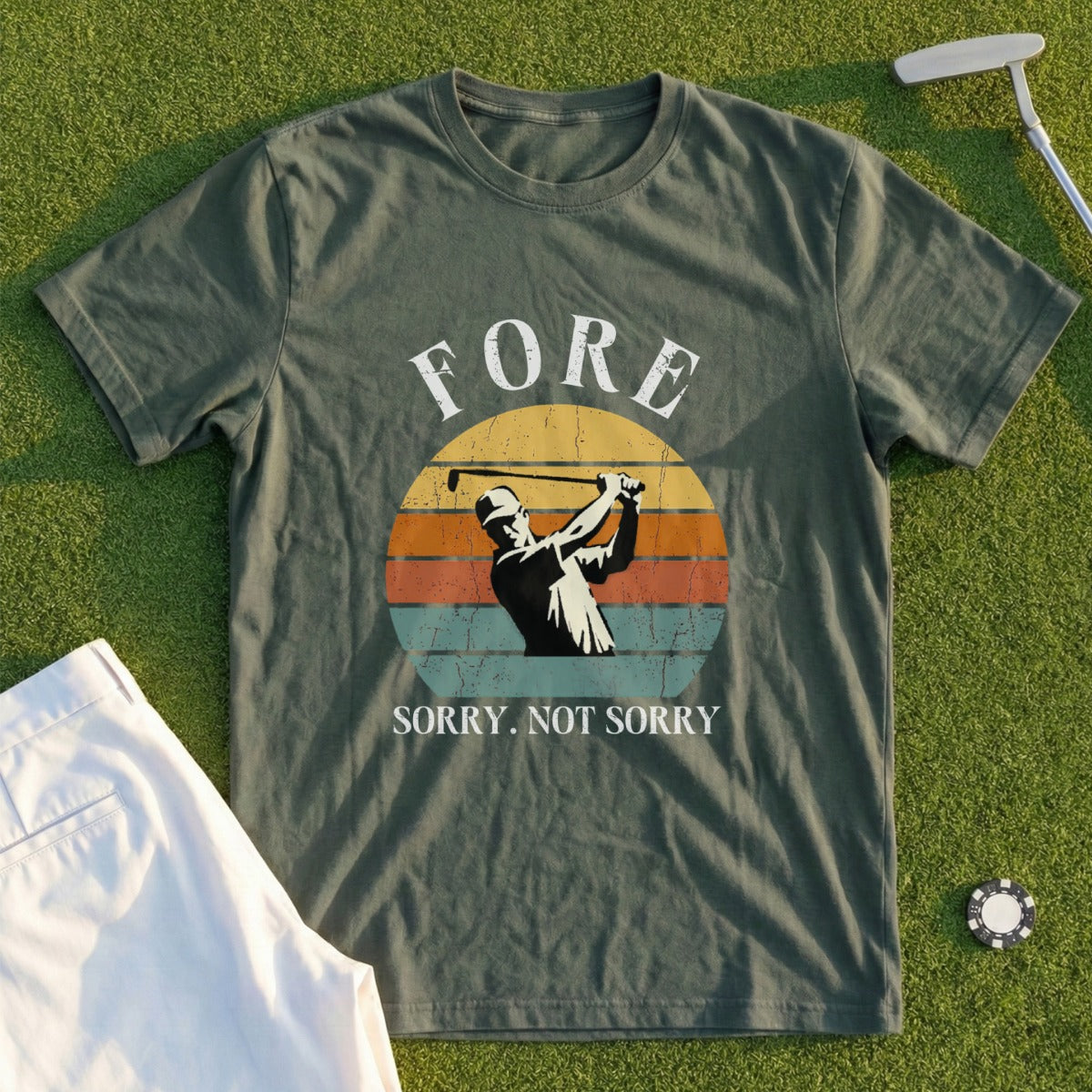 Olive green t-shirt with golfer graphic and "Fore. Sorry. Not Sorry." text.