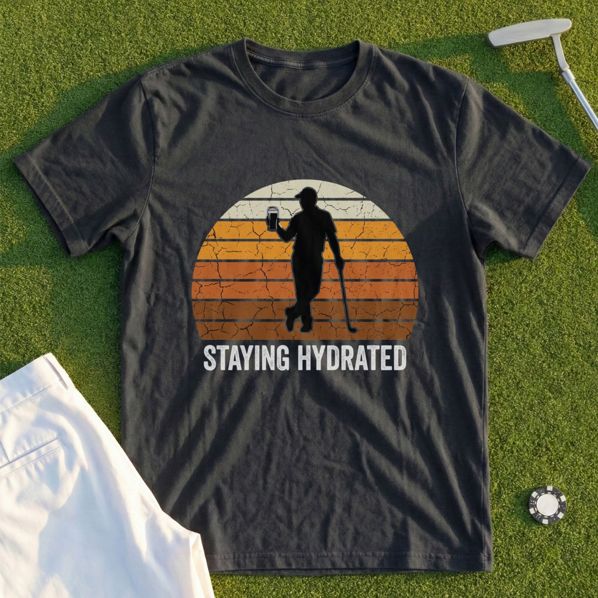 Dark t-shirt with retro graphic of a golfer holding a drink, text "STAYING HYDRATED".