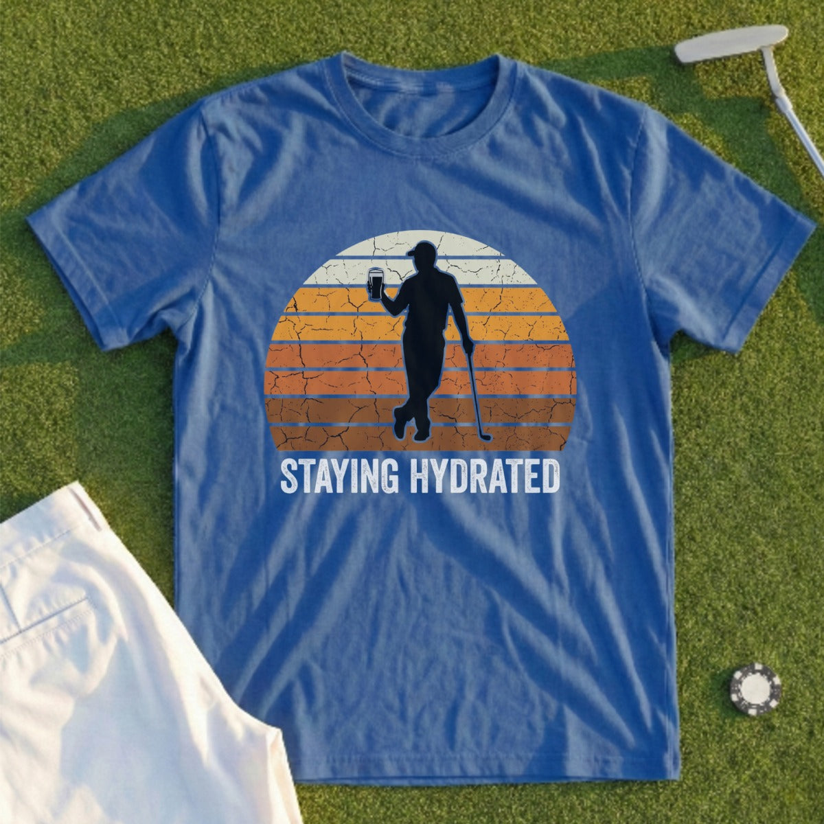 Blue t-shirt with "STAYING HYDRATED" text and golfer silhouette on sunset.