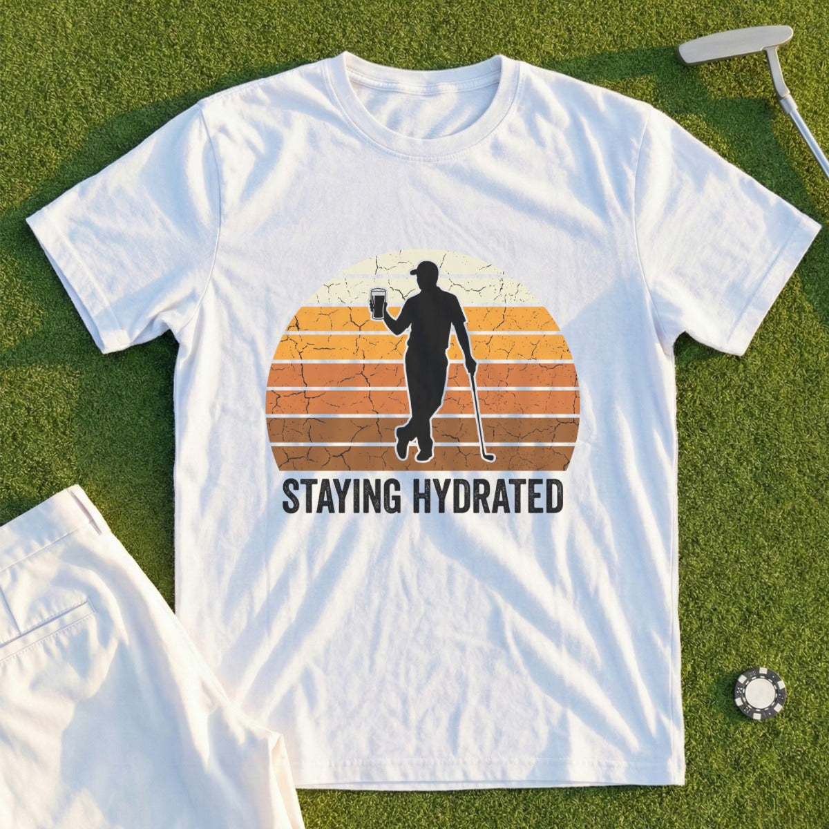 T-shirt graphic of golfer holding drink with "Staying Hydrated" text.