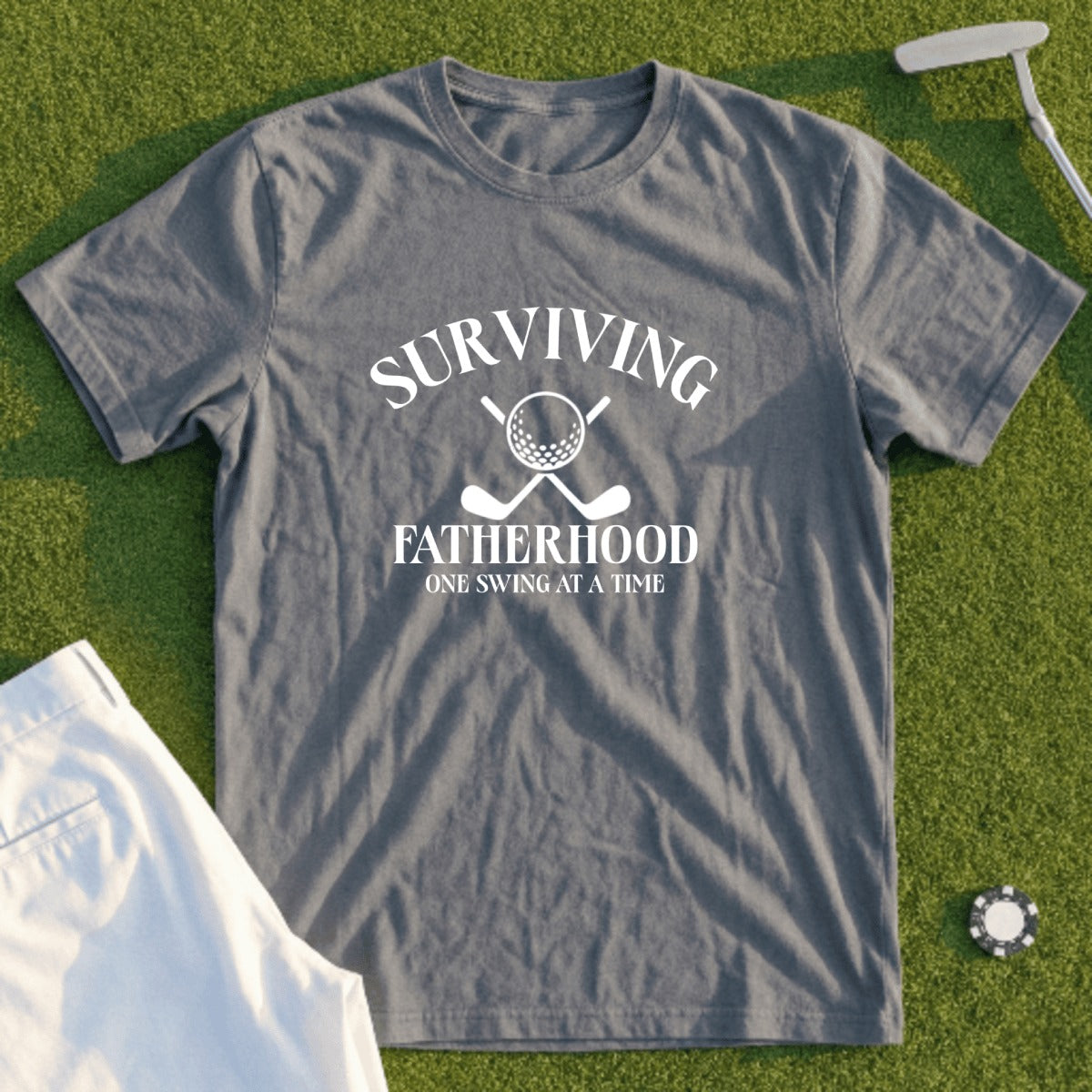 Grey t-shirt with "Surviving Fatherhood One Swing At A Time" and golf clubs.
