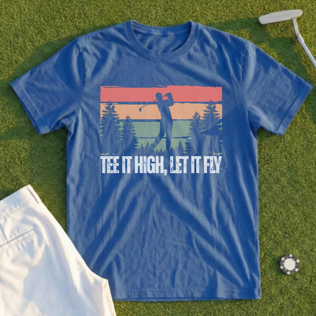 Blue t-shirt with golfer silhouette, trees, and text "TEE IT HIGH, LET IT FLY".