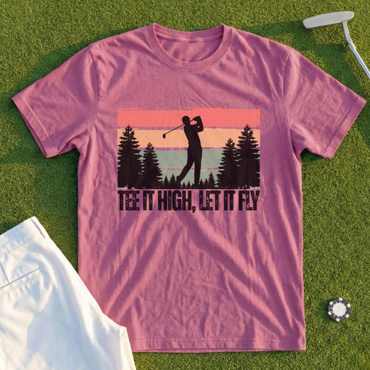 T-shirt with golfer silhouette, trees, and sunset design, text "TEE IT HIGH, LET IT FLY".
