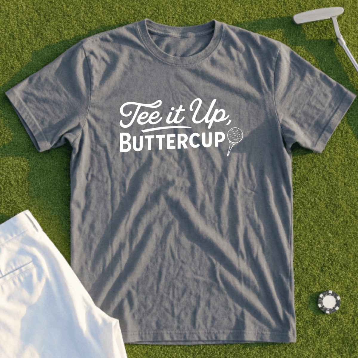 Grey t-shirt with white text "Tee it Up, Buttercup" and golf ball marker.