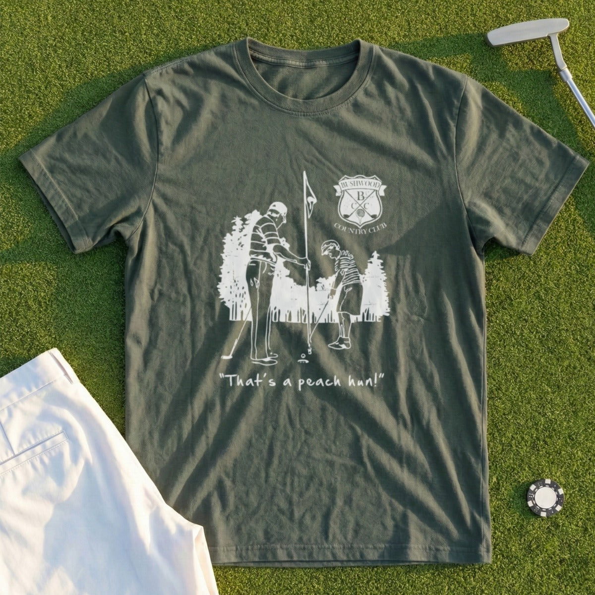 Green t-shirt with a sketch of two golfers and text "That's a peach hon!".