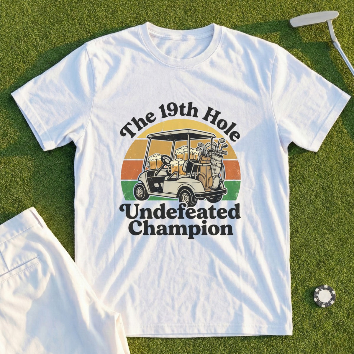 White t-shirt with "The 19th Hole Undefeated Champion" and golf cart graphic.