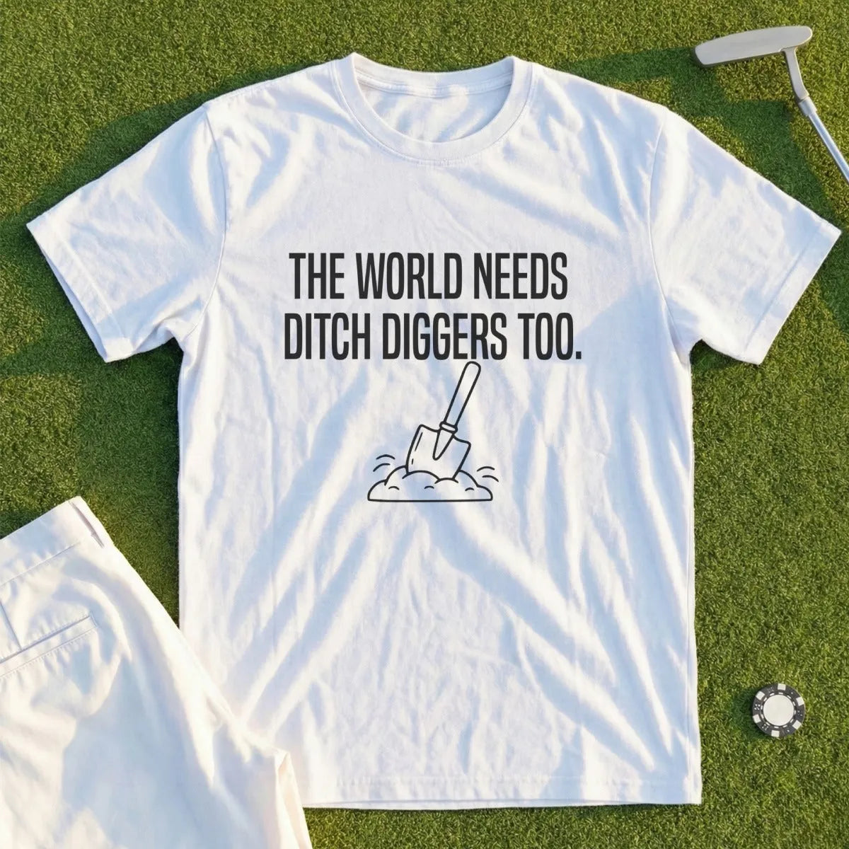 White t-shirt with text "The world needs ditch diggers too" and a shovel.
