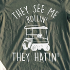 They See Me Rollin Tee, print close-up on Military Green