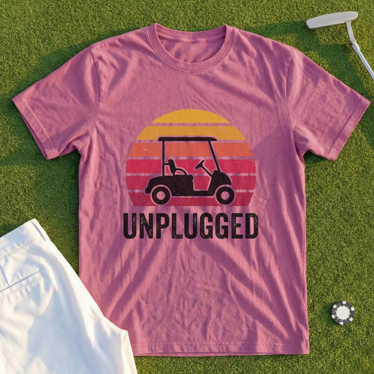 T-shirt with a golf cart and sunset graphic, text reads "UNPLUGGED."