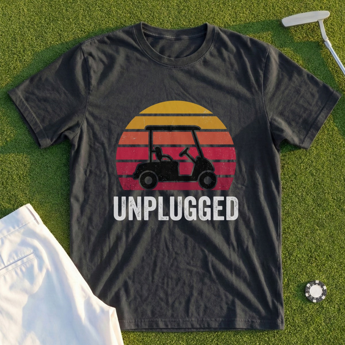 Dark t-shirt with a golf cart and sunset graphic, reads "UNPLUGGED".