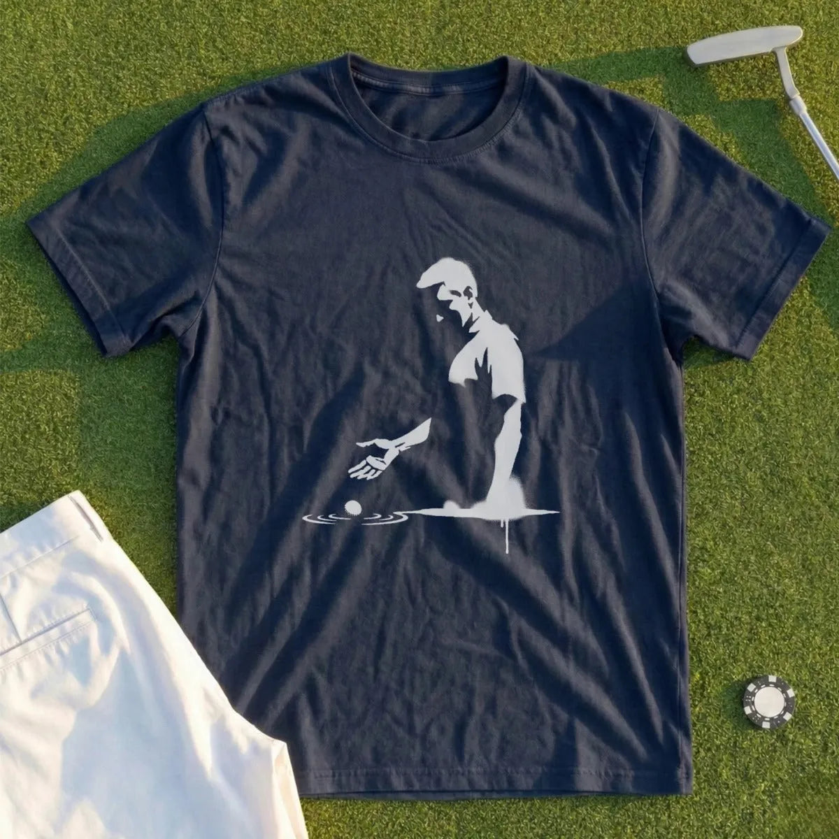 Navy t-shirt with white silhouette of golfer teeing off, golf ball on tee.