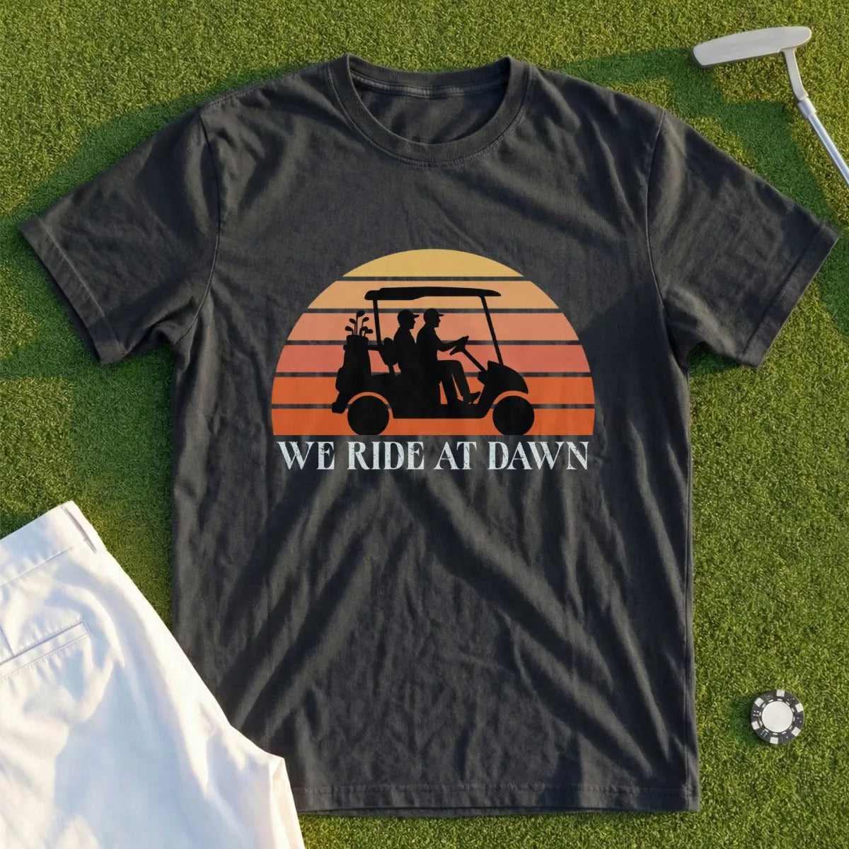 Black t-shirt with "We Ride At Dawn" text and golf cart silhouette against sunset.