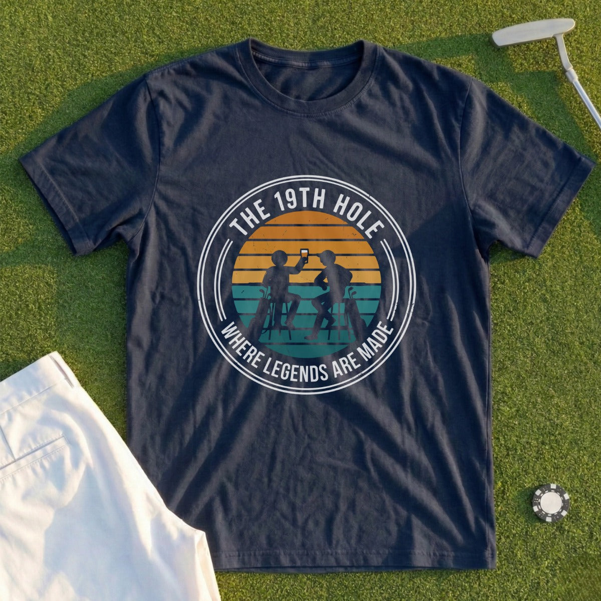 Navy t-shirt with graphic: "The 19th Hole Where Legends Are Made" and sunset scene.