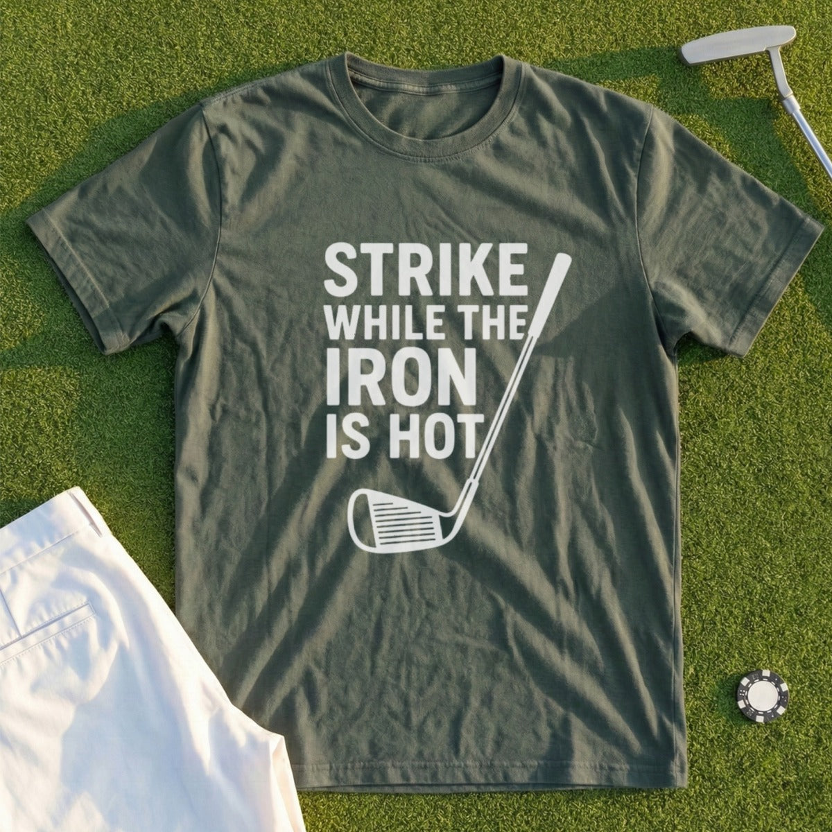 Olive t-shirt with "STRIKE WHILE THE IRON IS HOT" text and golf club graphic.