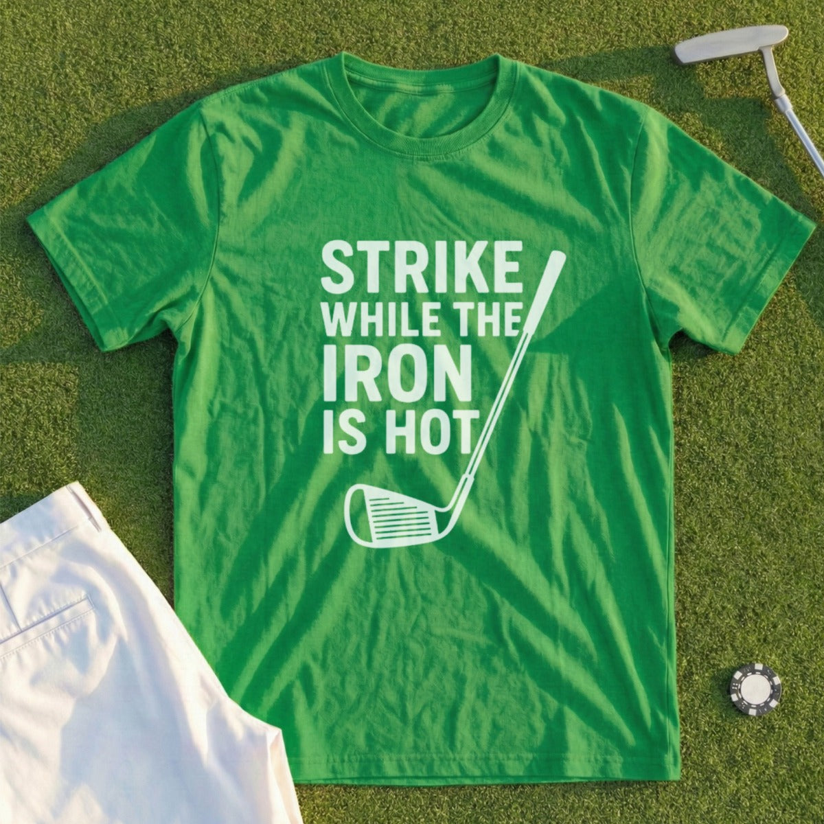 Green t-shirt with "STRIKE WHILE THE IRON IS HOT" text and golf club graphic.